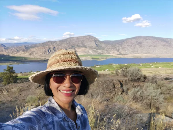 Osoyoos Gölü, Okanagan Vadisi, İngiliz Kolombiyası, Kanada yakınlarındaki manzara manzarasında selfie çeken genç bir bayan turist..