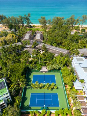 Phuket, Tayland - 20 Şubat 2024: Mai Khao, Phuket, Tayland 'daki JW Marriot Phuket Resort ve Spa Otel' deki tenis kortlarının insansız hava aracı görüntüsü.