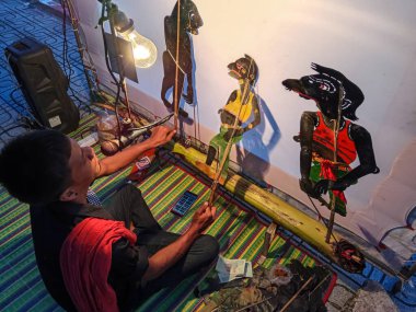 Songkhla, Tayland - 30 Aralık 2023: Geleneksel Tayland sanatçısı Nang Talung, Tayland 'ın güneyinden geleneksel gölge kuklaları sergiliyor. Nang yai gerçek boyutta kuklalara sahipken, Nang talung kuklaları çok daha küçüktür..