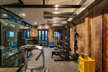 Bangkok, Tayland - 21 Kasım 2022: Bangkok, Tayland 'da bulunan lüks fitness ve egzersiz ekipmanlarına sahip bir ev içi spor salonu manzarası.