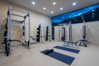 Phuket, Tayland - 21 Kasım 2024: Phuket, Tayland 'da bulunan lüks fitness ve egzersiz ekipmanlarına sahip bir ev içi spor salonu manzarası.