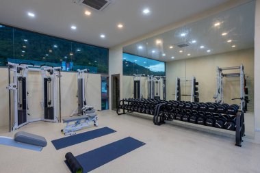 Phuket, Tayland - 21 Kasım 2024: Phuket, Tayland 'da bulunan lüks fitness ve egzersiz ekipmanlarına sahip bir ev içi spor salonu manzarası.