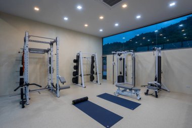 Phuket, Tayland - 21 Kasım 2024: Phuket, Tayland 'da bulunan lüks fitness ve egzersiz ekipmanlarına sahip bir ev içi spor salonu manzarası.