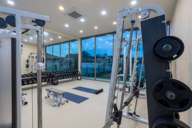 Phuket, Tayland - 21 Kasım 2024: Phuket, Tayland 'da bulunan lüks fitness ve egzersiz ekipmanlarına sahip bir ev içi spor salonu manzarası.