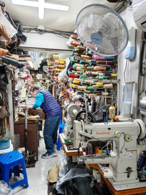 Seul, Güney Kore - 28 Ekim 2024: Myeong-dong, Seul, Güney Kore 'de bulunan küçük bir işletmede terzi dükkanında çalışan Koreli adam..