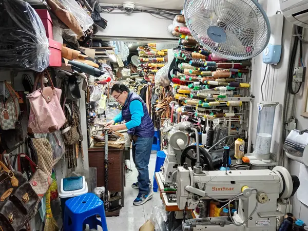 Seul, Güney Kore - 28 Ekim 2024: Myeong-dong, Seul, Güney Kore 'de bulunan küçük bir işletmede terzi dükkanında çalışan Koreli adam..