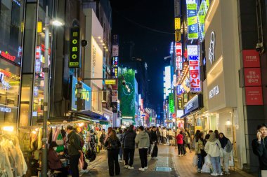 Seul, Güney Kore - 26 Ekim 2024: Canlı ve hareketli alışveriş bölgesi Myeong-Dong 'un Seul, Güney Kore' de bulunan ışıklı tabelalarla dolu olduğu sokak manzarası. 