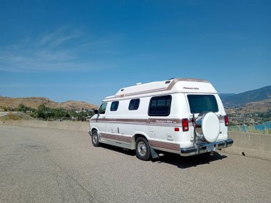 British Columbia, Canada - September 01, 2024: Parked camper van car over looking Kamalka lake during a road trip in Vernon, Okanagan Valley. clipart