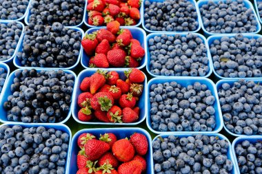 Fraser Valley, British Columbia, Kanada 'daki bir çiftçi pazarında mevsimlik taze böğürtlen ve çilek konteynerleri.