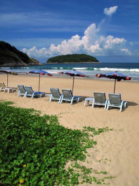 Phuket, Tayland 'daki Nai Harn plajında plaj sandalyeleri ve umbellalar..
