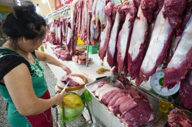 Ho Chi Minh City, Vietnam - 23 Ocak 2018: Vietnamlı kadın kasap Ben Thanh Market, Ho Chi Minh City, Vietnam 'da bir markette et kesiyor..