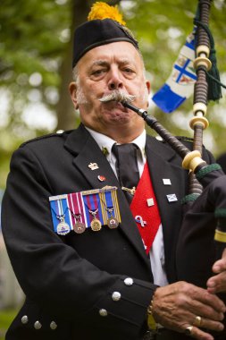 Richmond, British Columbia, Kanada - 1 Temmuz 2016: Richmond, British Columbia yakınlarındaki Steveston köyünde düzenlenen geçit töreninde gayda çalan ve Kanada bayramını kutlayan üniformalı bir Kanada lejyonu verteranı