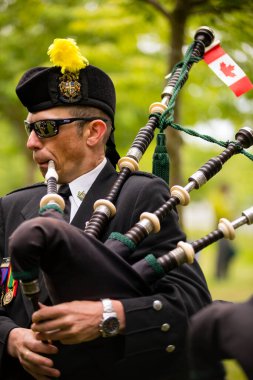 Richmond, British Columbia, Kanada - 1 Temmuz 2016: Richmond, British Columbia yakınlarındaki Steveston köyünde düzenlenen geçit töreninde gayda çalan ve Kanada bayramını kutlayan üniformalı bir Kanada lejyonu verteranı
