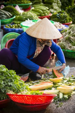 Duong Dong, Phu Quoc Island, Vietnam - January 25, 2018: Vietnamese market vendor cutting a fresh ripe papaya at the Duong Dong Market located in Duong Dong, Phu Quoc Island, Vietnam.