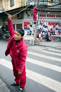 27 Ocak 2018 - Hanoi, Vietnam: Vietnamlı elektrikçi Hanoi, Vietnam 'da şehrin eski mahallesine kablo ve kablo döşedi.