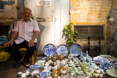 Ho Chi Minh City, Vietnam - 12 Ocak 2016: Ho Chi Minh City, Vietnam 'da yerel bir pazarda porselen satan Vietnamlı bir sokak satıcısı.