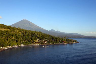 View of Amed Beach and Jemeluk Bay a coastal village that offers vibrant reefs, delicious seafood and stunning views of Mount Agung in Bali, Indonesia. clipart