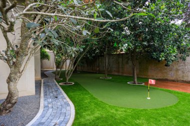 Phnom Penh, Kamboçya - 18 Şubat 2025: Kamboçya 'da Phnom Penh, Kamboçya' da lüks bir villanın arka bahçesine yapay çim çimenliği ve spor amaçlı bir golf sahası.