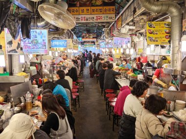 Seul, Kore - 28 Ekim 2024: Güney Kore 'de Namdaemun Market' te Kalguksu Sokağı 'ndaki bir markette Kore yemeği pişiren sokak yemekleri satıcısı. 