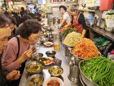 Seul, Kore - 28 Ekim 2024: Güney Kore 'de Namdaemun Market' te Kalguksu Sokağı 'ndaki bir markette Kore yemeği pişiren sokak yemekleri satıcısı. 