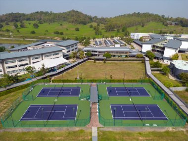 Chonburi, Tayland - 22 Mart 2025: Tayland 'ın Chonburi kentindeki özel bir İngiliz uluslararası eğitim okulu olan Rugby School Thailand' daki açık tenis kortlarının insansız hava görüntüsü. 
