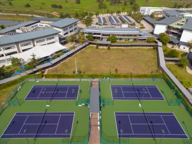 Chonburi, Tayland - 22 Mart 2025: Tayland 'ın Chonburi kentindeki özel bir İngiliz uluslararası eğitim okulu olan Rugby School Thailand' daki açık tenis kortlarının insansız hava görüntüsü. 