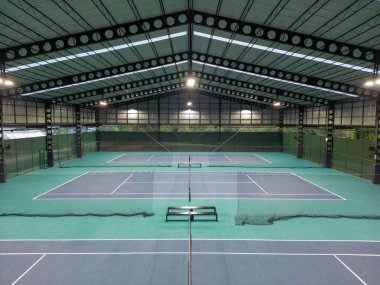 Phuket, Tayland - 12 Mart 2025: Phuket, Tayland 'daki The Peak Racquet Park' taki kapalı tenis kortlarının insansız hava aracı görüntüsü.