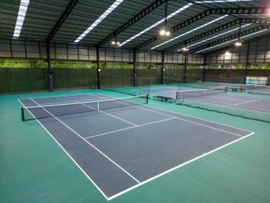 Phuket, Tayland - 12 Mart 2025: Phuket, Tayland 'daki The Peak Racquet Park' taki kapalı tenis kortlarının insansız hava aracı görüntüsü.
