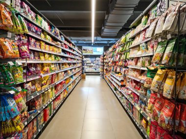 Penang, Malezya - 20 Aralık 2024: Penang, Malezya 'da bulunan Village Grocer' daki paketlenmiş abur cubur market rafının iç görünümü.