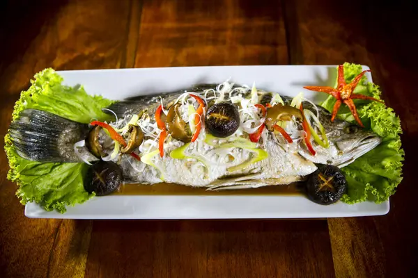 Tayland usulü soya soslu tilapia balığı ve limon suyu ve Çin mantarı..