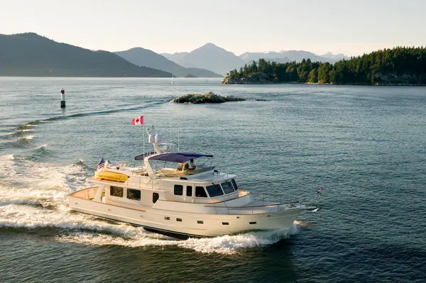 West Vancouver, British Columbia, Kanada 'daki Deniz feneri parkı yakınlarındaki Burrard körfezinde seyreden lüks bir yatın hava görüntüsü..