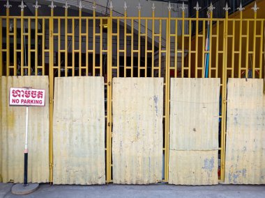 Phnom Penh, Kamboçya - 27 Şubat 2025: Kapalı metal kepenk kapısında park yasağı var. Phnom Penh, Kamboçya 'da bulunan kapı, bölgeye giriş çıkışları engelliyor..
