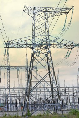 Tarlada elektrik kabloları olan büyük bir direk, bulutlu gökyüzüne karşı. Yüksek kalite fotoğraf