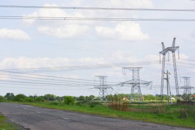 Ukrayna 'da yol kenarındaki bir köyde, bir tarlada kablolu elektrik direkleri bulunmaktadır. Yüksek kalite fotoğraf