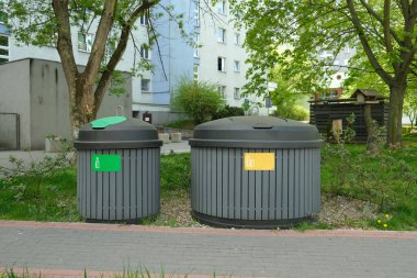 Two round, large gray garbage cans for sorting garbage stand on the street, in the city. High quality photo