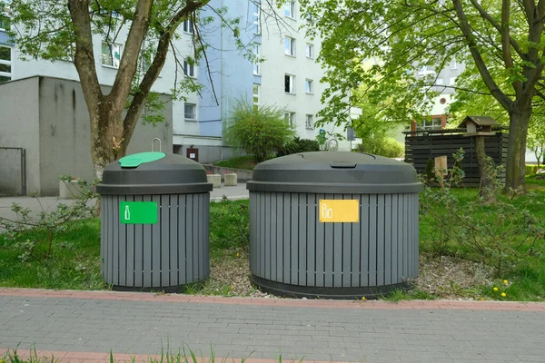 Two round, large gray garbage cans for sorting garbage stand on the street, in the city. High quality photo