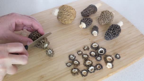 一个男人在厨房切春菇 春菇整整齐齐切成片摆在桌上 从野生的或农场种植的莫雷尔蘑菇中烹调菜肴的想法 高质量4K — 图库视频影像
