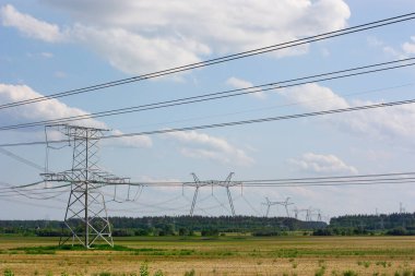 Yüksek ve alçak elektrik direkleri beyaz bulutlarla gökyüzüne karşı. Yüksek kalite fotoğraf