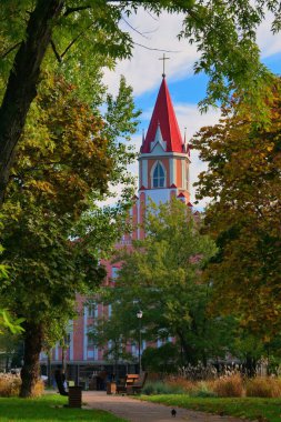 Ukrayna 'nın başkenti Kyiv' deki Avrora parkı yakınlarındaki Yedinci Gün Adventistleri Kilisesi 'nin resimli görüntüsü. Sonbahar renklerinde ağaçlarla kaplı patika boyunca uzanan bankların manzarası çok güzel. Mavi gökyüzü arkaplanı.