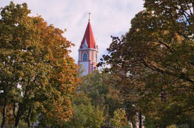 Ukrayna 'nın başkenti Kyiv' deki Avrora parkı yakınlarındaki Yedinci Gün Adventistleri Kilisesi 'nin manzarası. Şehir parkındaki güzel manzara sonbahar renkleri ağaçlar. Mavi gökyüzü arkaplanı.