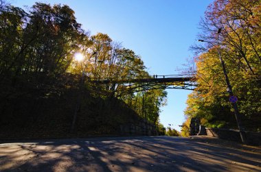 Mariyinsky Park, Kyiv, Ukrayna 'daki ünlü Aşıklar Köprüsü' nün geniş açılı manzarası. Köprü yolda. Arka planda renkli sonbahar ağaçları.