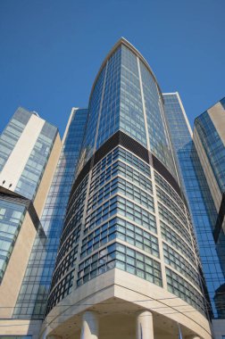 Ukrayna, Kyiv 'deki modern yüksek binaların alçak açılı görüntüsü. Camdan, çelikten ve betondan modern mimari kavramı. Mavi gökyüzü arkaplanı.
