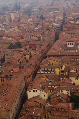 Scenic bird-eye view from the top of the tower on Bologna old town center. Vintage buildings with red tile roofs. Famous touristic place and travel destination in Europe. UNESCO World Heritage Site.