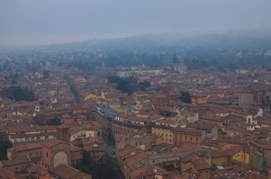 Scenic bird-eye view from the top of the tower on Bologna old town center. Vintage buildings with red tile roofs. Famous touristic place and travel destination in Europe. UNESCO World Heritage Site.