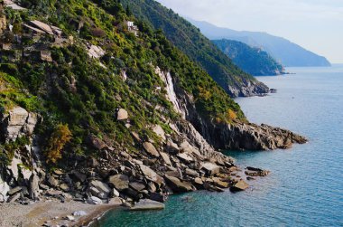 Aerial nature landscape view of beautiful rocks descend into the Ligurian Sea. Sea landscape with mountains covered by different plants, cacti and trees. Concept of landscape and nature. Cinque Terre.