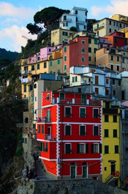 Scenic landscape with colorful buildings built on the rocks. Amazing view of Riomaggiore village. Famous touristic place and travel destination in Italy. The Cinque Terre. UNESCO World Heritage Site.