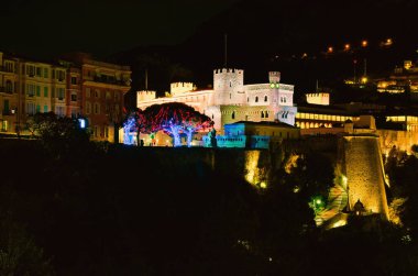 Scenic nightlight landscape of beautiful illuminated castle in Monaco. Prince's Palace of Monaco is the official residence of the Prince of Monaco. Travel and tourism concept.