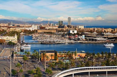 Barcelona, Spain-January 02,2016:Scenic aerial landscape view of Port Vell with moored yachts and ships, Maremagnum shopping mall. Downtown of Barcelona in the background. Travel and tourism concept. 
