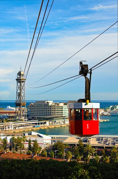 Famous red cablecar with people over the port in Barcelona. Transportation from Montjuic to the harbor of Barcelona. Port Cable Car built for Universal Exhibition of 1929. Travel and tourism concept.