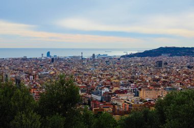 Scenic aerial landscape view of colorful residential buildings in downtown of Barcelona. Panoramic cityscape of Barcelona during sunny day. Mountains in the background. Travel and tourism concept.
